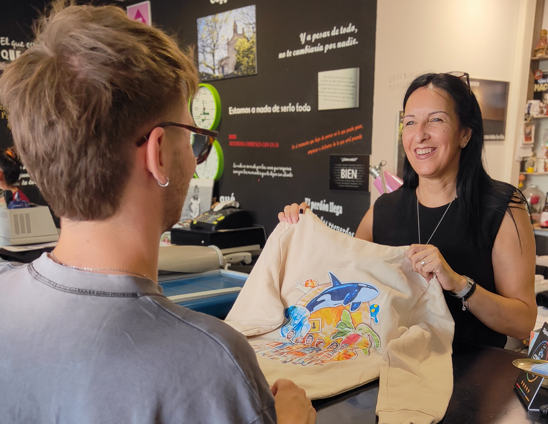 Roser mostrando una sudadera personalizada a un cliente en Copy Art, Sant Boi de Llobregat